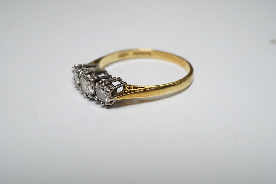 A modern 18ct gold and three stone diamond set ring, size M, gross weight 2.1 grams. Condition - fair to good